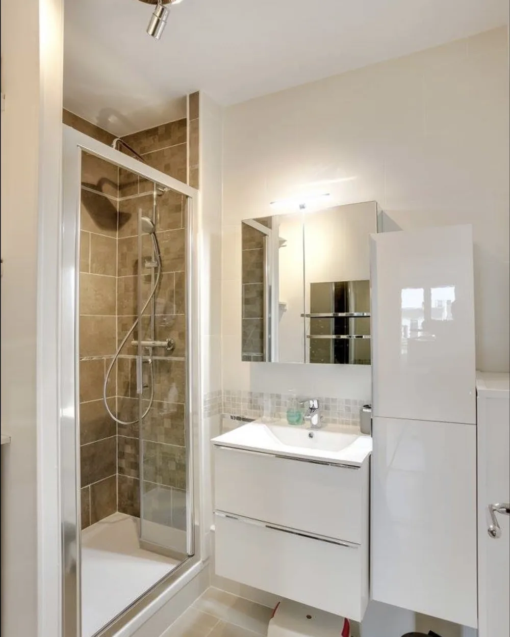 Salle de bain rénovée, douche vitrée et meuble suspendu blanc