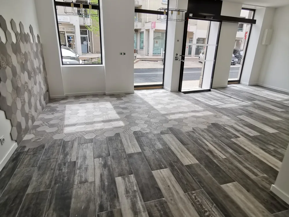 Local rénové, parquet gris posé en chevrons et vitrines