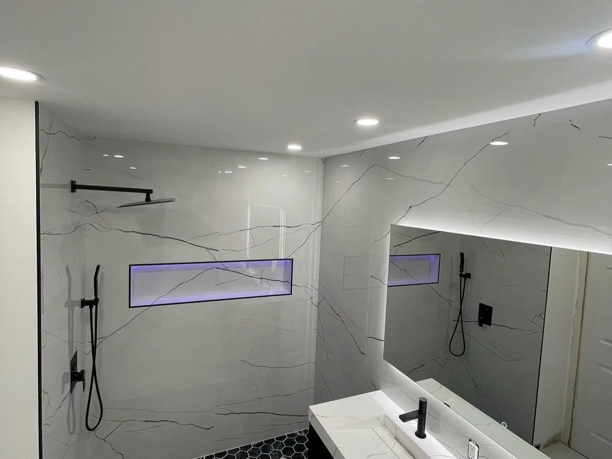 Salle de bain rénovée, douche à l’italienne et robinetterie noire